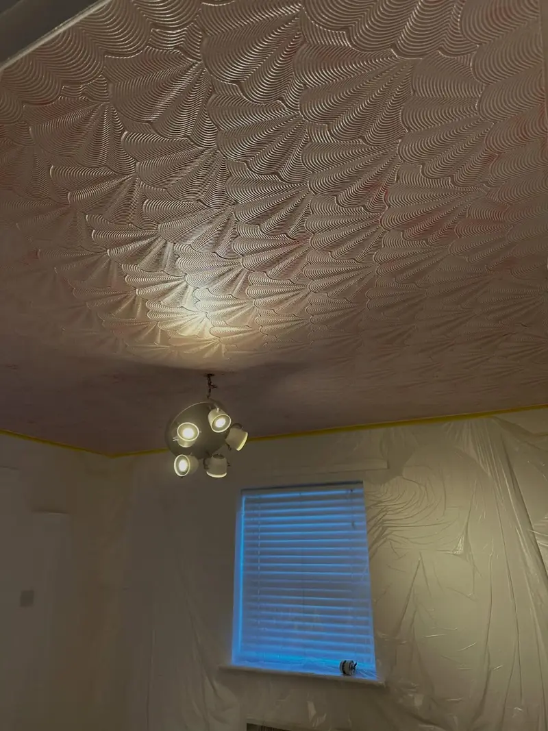 A swirled Artex ceiling in Wickford before work, with the walls sheeted up