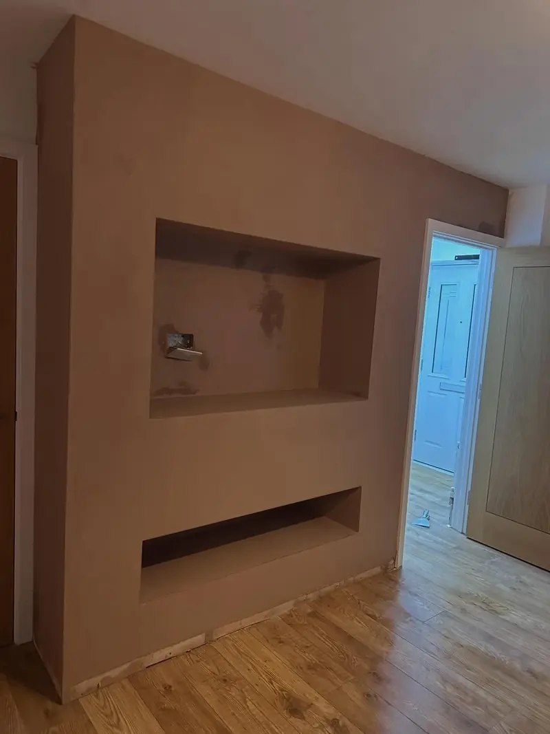 A plastered media wall with TV and fire recesses in Laindon